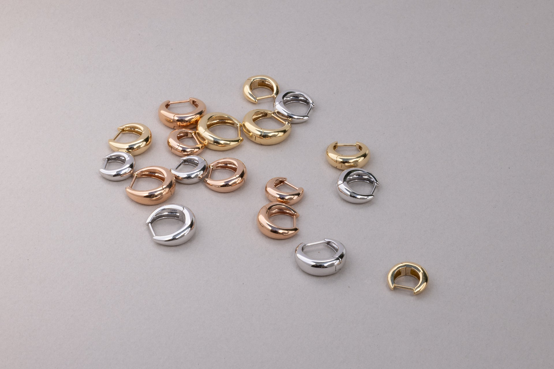 picture of 18k gold signature tapered hoops in yellow gold, white gold, and rose gold in size 6.5mm, 8mm, and 9.5mm