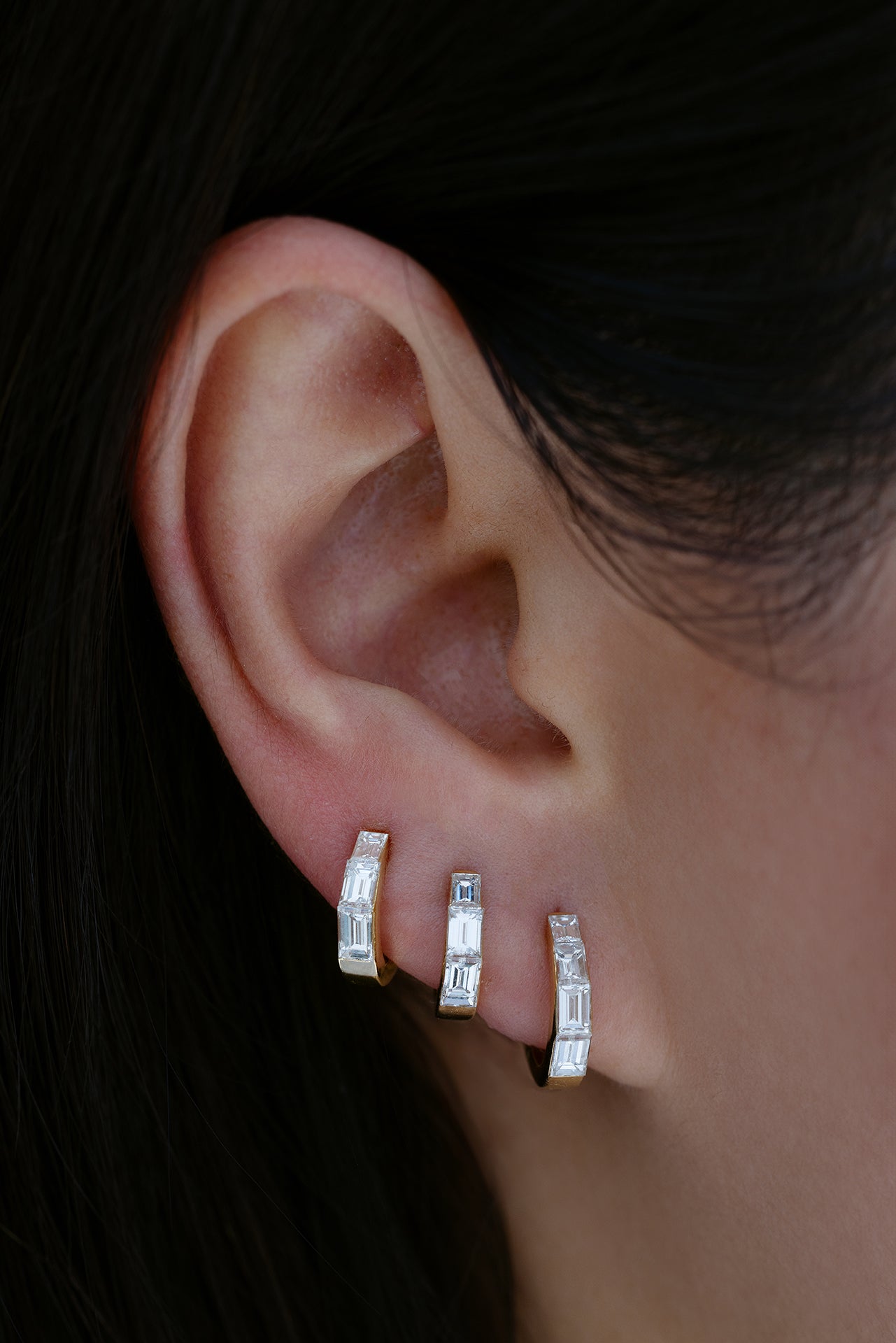 18k yellow gold baguette diamond tapered hoops in sizes 6.5mm, 8mm, and 9.5mm