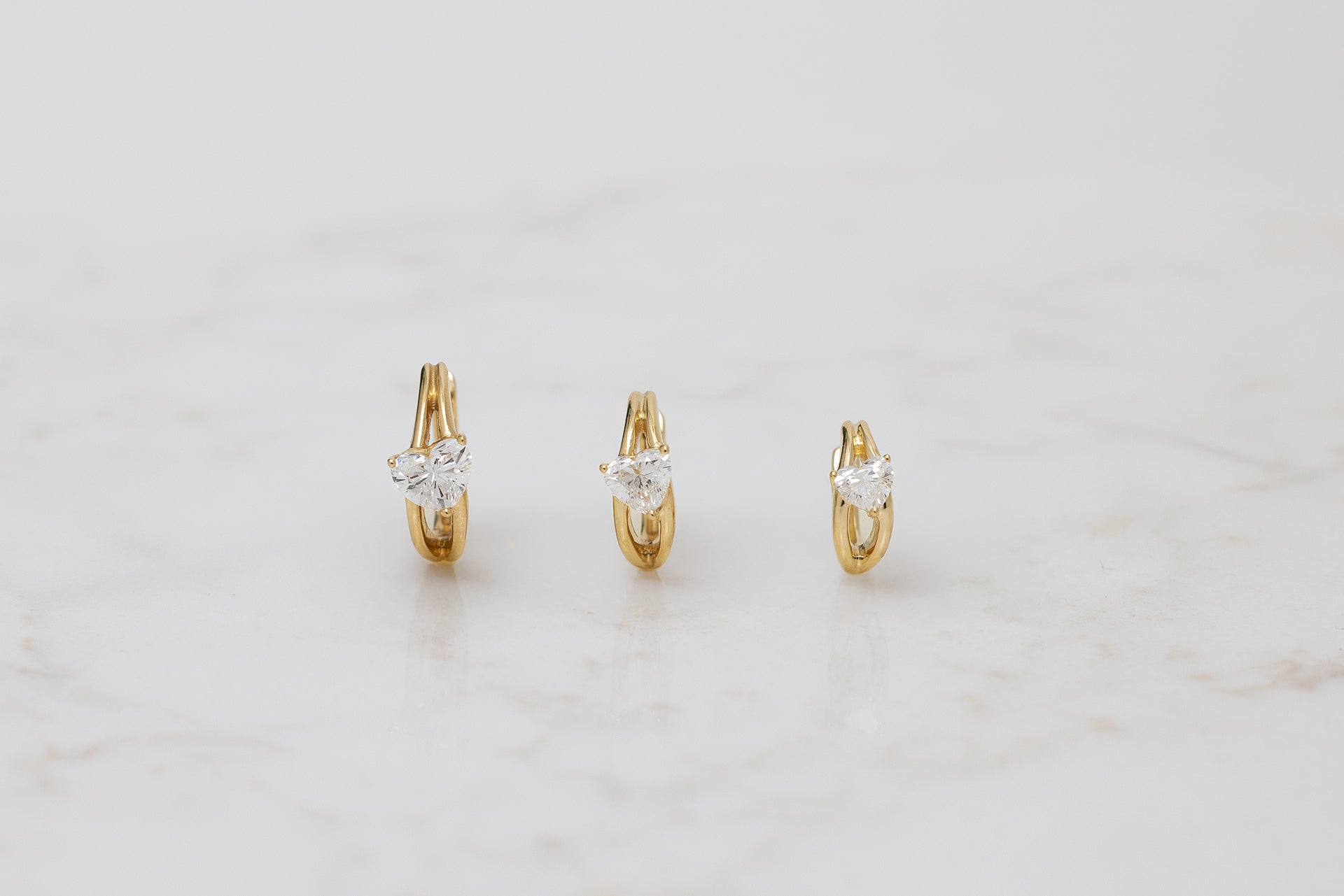 18k yellow gold hoop with diagonal heart diamond center in three sizes 9.5mm, 8mm, 6.5mm